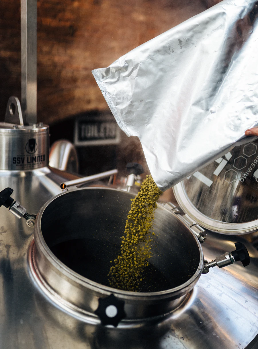 Lúpulo vertiéndose en la olla de cocción de la cervecería